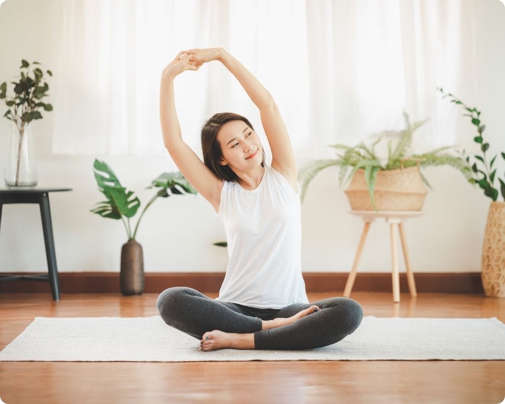 Nurse sitting on floor doing easy yoga for the busy nurse.