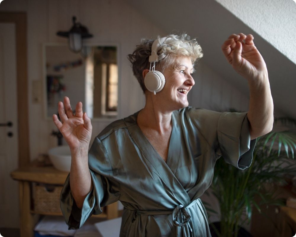 Nurse dancing around her living room. She is engaging in self-care activities for nurses.