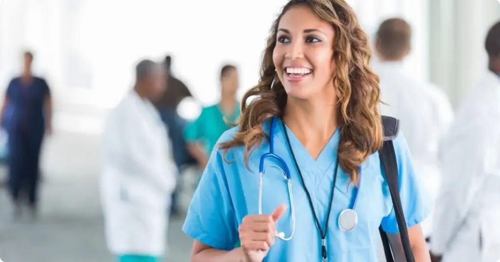 A smiling nurse walking confidently down a hospital hallway, appearing relaxed and focused after practicing mindfulness.