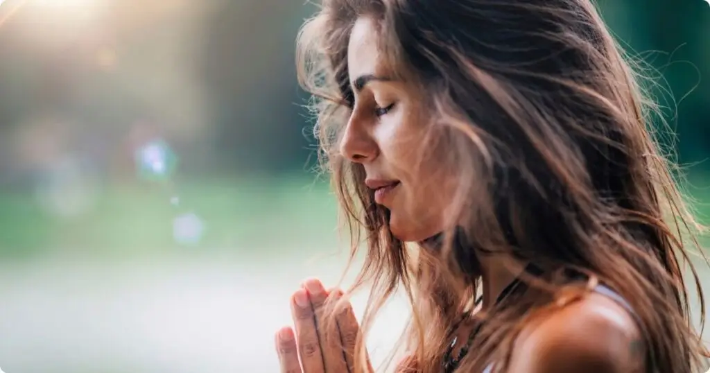 A nurse sitting in peaceful reflection, taking a deep breath with eyes closed, symbolizing a moment of self-care.