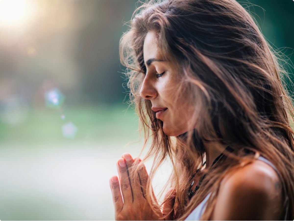 A nurse sitting outside a hospital, gazing down with a peaceful expression, symbolizing a nurse recovering from compassion fatigue.