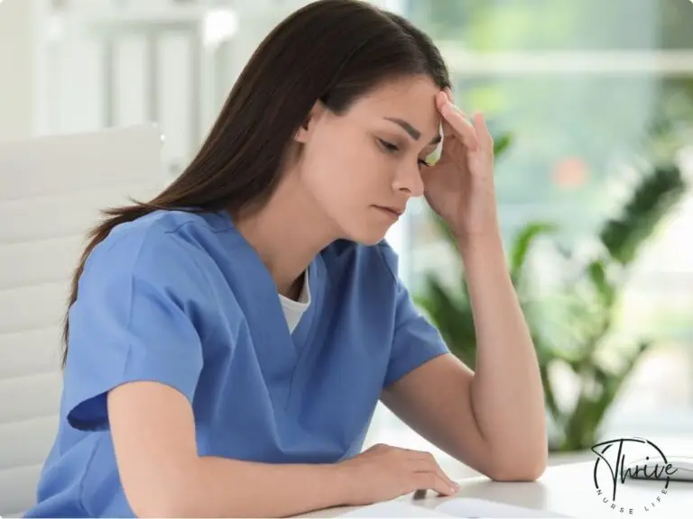 A fatigued nurse sits in a breakroom, holding her head in her hands, representing the emotional toll of compassion fatigue in healthcare.